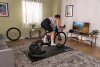 Tacx Nēra – cyklistka trénuje na trenažéru v obývacím pokoji před televizí