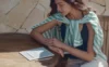 Žena čte na e-ink tabletu Onyx Boox Go 10.3 na dřevěném stole ve slunci, vedle leží stylus
