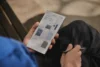 reMarkable Paper Pro Move – tablet v ruce, na displeji knihovna se sešity a barevnými obálkami, v druhé ruce pero Marker