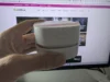 Stolní vysavač Odistar v dlani před monitorem s webem GeekLife.cz
