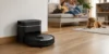 TP-Link Tapo RV30 Max Plus Gen 2 – černý robotický vysavač zaparkovaný u dokovací stanice v obývacím pokoji, v pozadí rodina na pohovce a pes na koberci