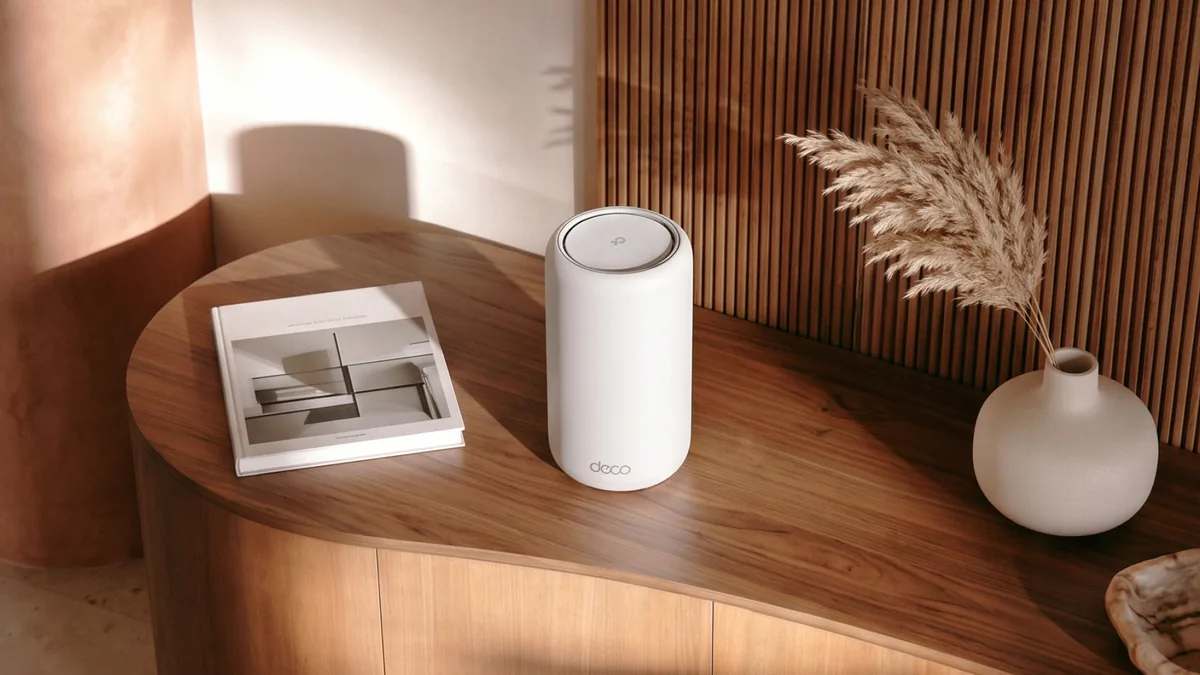 Wi-Fi 8 od TP-Linku: Archer 8 Ultra slibuje 19 Gb/s a mesh Deco pokryje 910 m² 2 TP-Link Deco 8 Ultra — bílá válcová mesh jednotka na dřevěné komodě vedle knihy a vázy se sušenou travinou